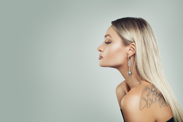 Luxurious Woman with Healthy Blonde Hairstyle, Makeup and Black Pearls Earrings on Background with...