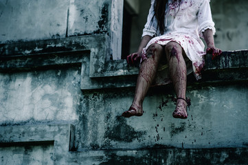 Horror Scene of a Woman with Bloody leg .Zombie woman  sitting hanging legs on building is...