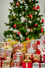 Christmas tree and many present boxes.in bedroom.
