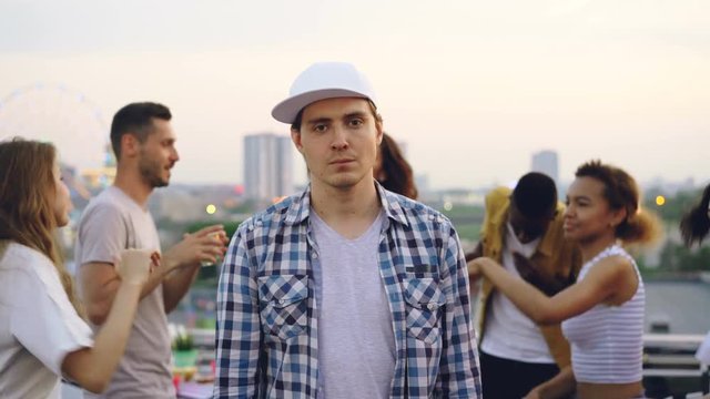 Portrait Of Sad Handsome Man Looking At Camera At Rooftop Party Then Starting Dancing, Jumping And Having Fun. Entertainment, Modern City And People Concept.