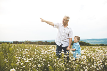 grandfather spending time with little child during the sunset.