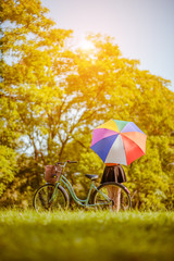 Relaxing woman at nature With colorful umbrellas and her bike.