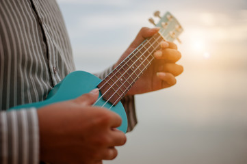 Fototapeta premium Man playing ukulele at the beach