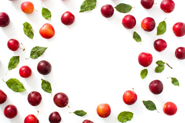 Red and yellow plums pattern on white background. Copyspace
