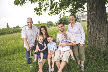 Fototapeta premium Family with grandparent spending time with little child during the sunset.