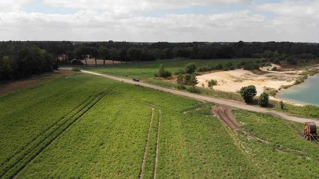 Flight with the drone over a field next to a sand pit back towards the helmsman of the UAV