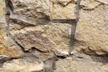The wall is made of beige stones of different shapes.