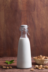 Bottle of almond milk on a dark wooden table
