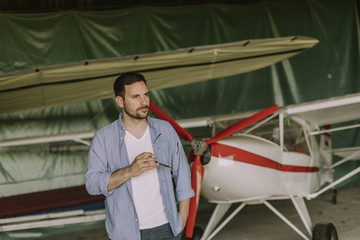 Young man in the airplane hangar