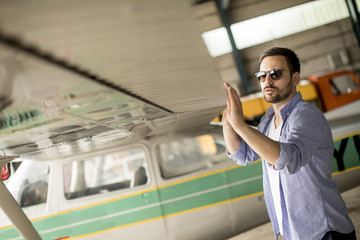 Handsome young pilot checking his ultralight airplane before flight © BGStock72