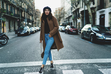 Elegant business woman enjoying walking the city after hard working day. Student girl in a trendy...