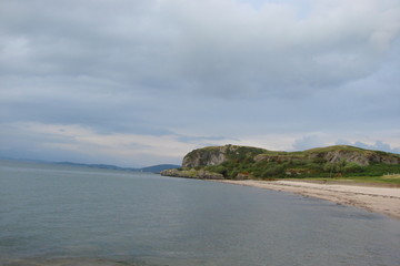 Fototapeta premium Scenic landscape of the Scottish coast of the Gulf on the background of a cloudy sky at sunset.