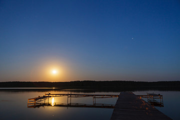 Fototapeta na wymiar Evening landscape of moon rise over calm lake