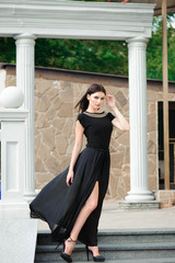 young woman in a long black dress down the stairs