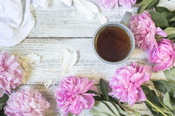 Beautiful still life with tea cup and peonies. Top view