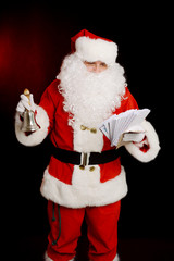 Santa Claus holding hand bell and children's letters