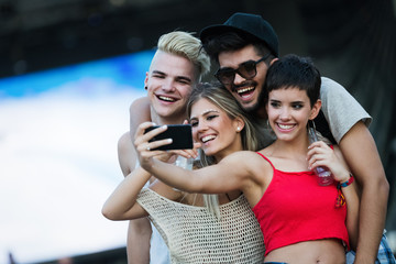 Happy friends having fun at music festival