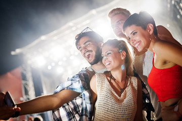 Happy friends having fun at music festival