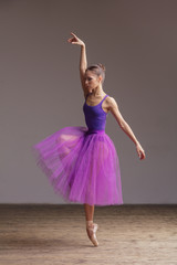 Naklejka premium Young beautiful ballerina is posing in studio
