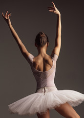 Young beautiful ballerina is posing in studio