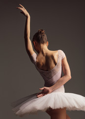 Young beautiful ballerina is posing in studio