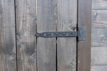 close up of old wooden door with rusty iron door hinge