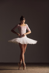 Young beautiful ballerina is posing in studio