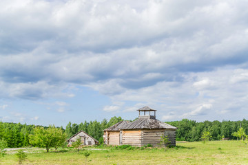 wooden house at the edge of the forest under dramatic sky
