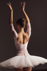 Naklejka premium Young beautiful ballerina is posing in studio