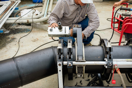 Worker Are Cutting Pe Pipes With Electric Cutters For Use In Welding Plumbing In Factories.