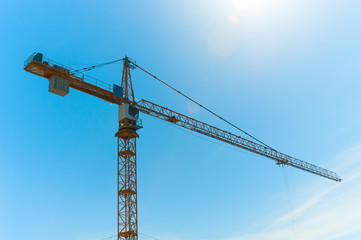 Construction crane tower against blue sky