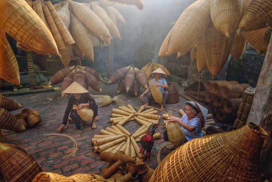 Vietnamese fishermen are doing basketry for fishing equipment at morning in Thu Sy Village, Vietnam.