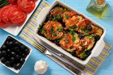 Eggplant casserole with mozzarella , tomatoes and olives.