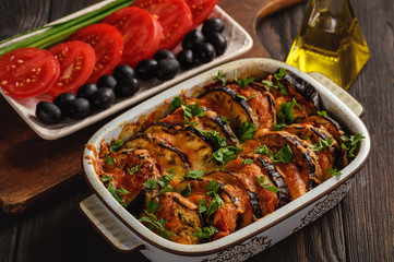 Eggplant casserole with mozzarella , tomatoes and olives.