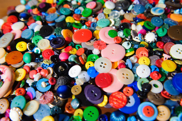 Fototapeta na wymiar Lot of colorful plastic clothing buttons. Many small round vintage buttons pattern background