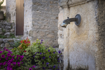Water spout and flowers in the village of Vaison-la-Romaine Carpentras Vaucluse Provence-Alpes-Côte d'Azur France