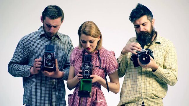 Concept of antique cameras. Photographer's studio. Three young photographers.