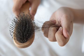 woman looking at her hair for hair loss problem