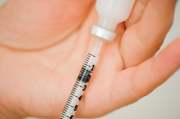 Girl picking up insulin in a syringe close-up. Diabetes.