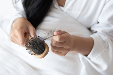 woman looking at her hair for hair loss problem