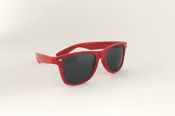 Czerwone okulary przeciwsłoneczne z czarnymi szkłami, wyizolowane na białym tle