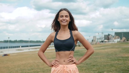 Mid section portrait happy smiling of fit woman's torso with her hands on hips. Female runner outdoors slim skinny belly stomatch muscles abdominal.