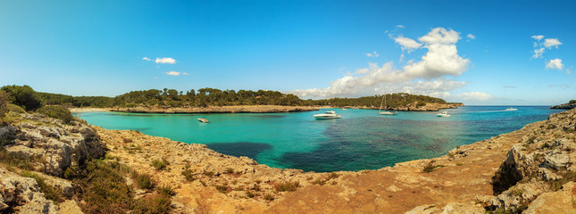 Beautiful coastal landscape with rocks and clear crystal turquoise sea on a sunny day. Cala s'Amarador beach cove panorama in Majorca Spain. Vacation concept.