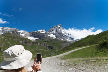 Fototapeta na wymiar Happy tourist on a mountain landscape at Matterhorn in italian Alps.