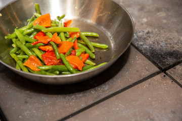 process of cooking vegetables. Asparagus and bell pepper in a frying pan