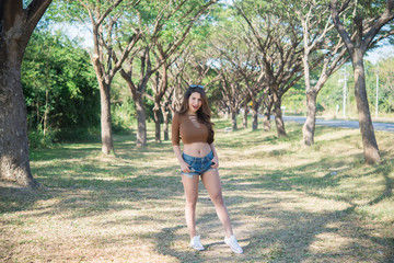 Portrait of Sexy asian woman at tunnel trees in daylight,Thailand people,Beautiful slim woman pose for take a picture