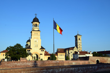 Orthodox Reunification Cathedral and Catholic St. Michael's Cathedral, with Romania flag. Alba Iulia in Transylvania, Romania
