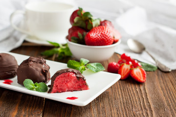 Strawberry ice cream balls in chocolate
