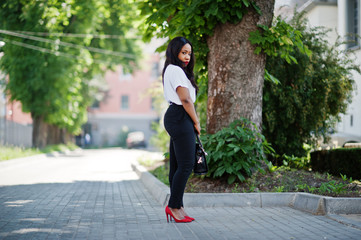 Stylish african american business woman on streets of city.