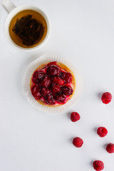 Tartlet with raspberries and a cup of green tea